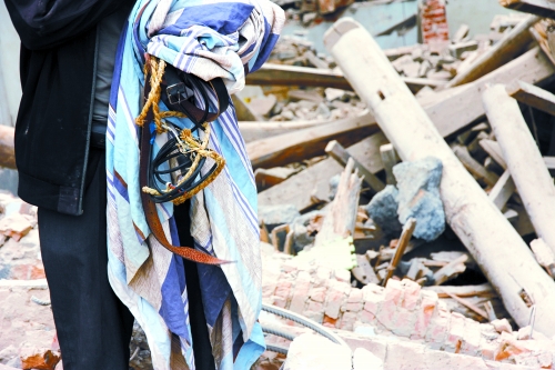 老人手中拿著曾控制住他的電線、床單