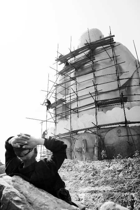 今年4月26日，工作人員將帆布蓋在“佛像”頭像上