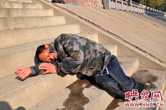 這名男子的衣服以及褲子全濕透了，水從衣褲里流出來，嘴里散發(fā)著濃烈的酒氣。