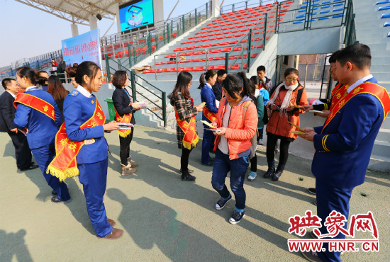 活動現(xiàn)場工作人員給同學們發(fā)放宣傳冊、環(huán)保袋。