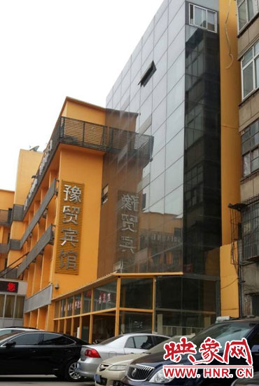 該酒店為加蓋樓層統(tǒng)一安裝上黑色玻璃，從前面看不出加蓋的痕跡