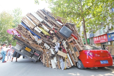 紅色小轎車被砸，卡在路邊動(dòng)彈不得。