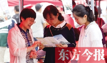 家長(zhǎng)和孩子在高招咨詢(xún)會(huì)上咨詢(xún)學(xué)校信息