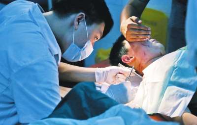 孩子身上有7道傷痕，其中兩道需要縫合，其他的均為擦傷，醫(yī)生正對(duì)他施治。