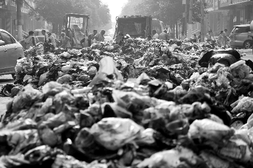 垃圾堆滿整個路口，環(huán)衛(wèi)工人們正在清理