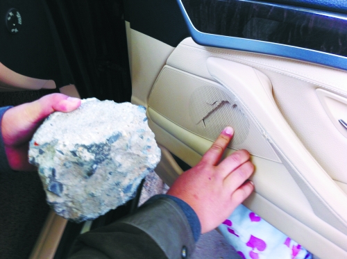 “飛”進(jìn)寶馬車內(nèi)的大石塊,將寶馬車的車門內(nèi)飾板砸爛。