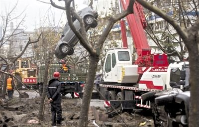輸油管道爆炸后，搶修人員將被炸毀的車輛運(yùn)出現(xiàn)場(chǎng)。