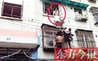 施救現(xiàn)場，劉鵬（圈內(nèi)）先用繩子捆住老太確保安全 勞動報(bào)記者 郭娜 供圖