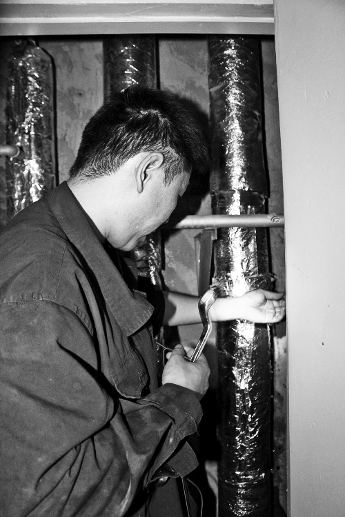 苗師傅一邊進行維修，一邊用耳機接聽市民的電話。