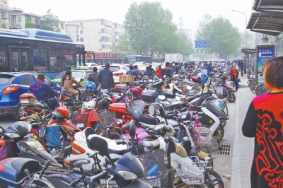 省人民醫(yī)院北門，路邊的公交站牌處停滿非機(jī)動(dòng)車，上、下客只能在快車道上。