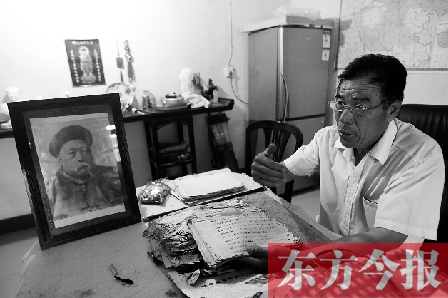 　魏樹紹手拿《物權法講義》手稿，在講訴先祖書寫“物權法”的歷史（相框里就是魏聯(lián)奎）