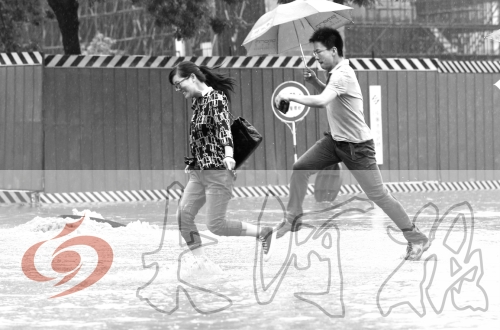 鄭州經(jīng)三路與北環(huán)交叉口處，積水較深，行人們不得不“練輕功”。 記者 白周峰 攝影