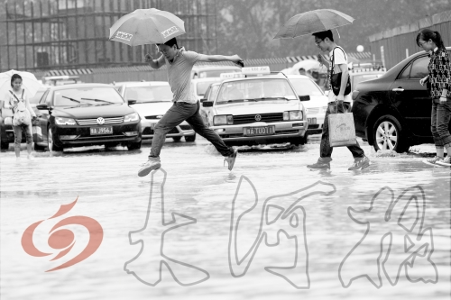 鄭州經(jīng)三路與北環(huán)交叉口處，積水較深，行人們不得不“練輕功”。 記者 白周峰 攝影