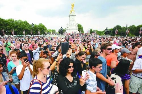 7月23日，在英國倫敦白金漢宮外，民眾們爭相閱讀“王室寶寶”出生的正式公告。