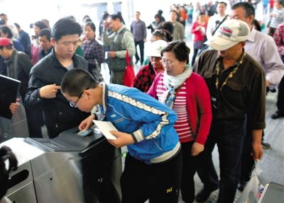 去年5月5日，14號(hào)線園博園站，乘客刷卡出地鐵。北京公交地鐵將實(shí)行計(jì)程票制，多乘坐多付費(fèi)。