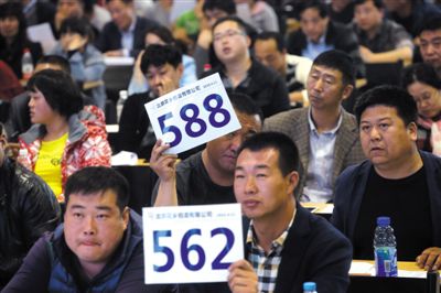 昨日，拍賣現(xiàn)場競拍者舉牌競拍。新京報記者