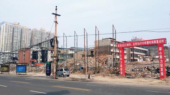 015年5月31日，在社區(qū)干部的帶頭拆遷下，親賢社區(qū)的“城中村改造”拉開帷幕。由于前期“清產(chǎn)核資”及補(bǔ)償標(biāo)準(zhǔn)等因素，拆遷改造工作推進(jìn)并不順利。圖為位于體育西路東側(cè)集體所有的商鋪率先被拆遷完畢，用于遮擋的圍擋正在施工中。（拍攝：2015年9月16日）