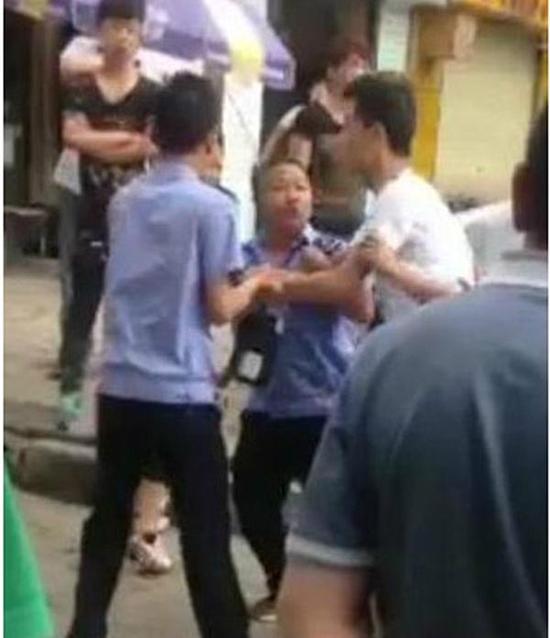 付某（右）與城管執(zhí)法人員廝打在一起。