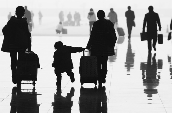 昨日，鄭州東站，一名孩子拉著媽媽和包裹快樂(lè)地奔走在春運(yùn)的途中