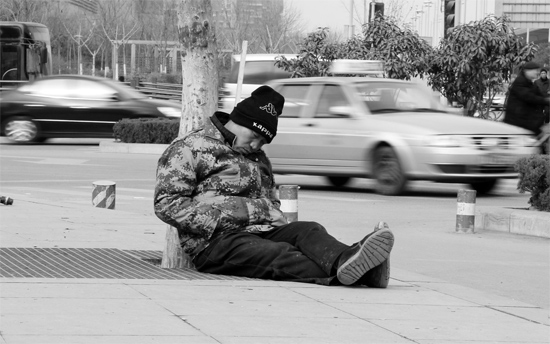 2月2日，鄭州市中州大道農(nóng)業(yè)路立交橋下，50歲的王文德打算在臨近春節(jié)前再接些零活兒，由于疲憊，他睡著