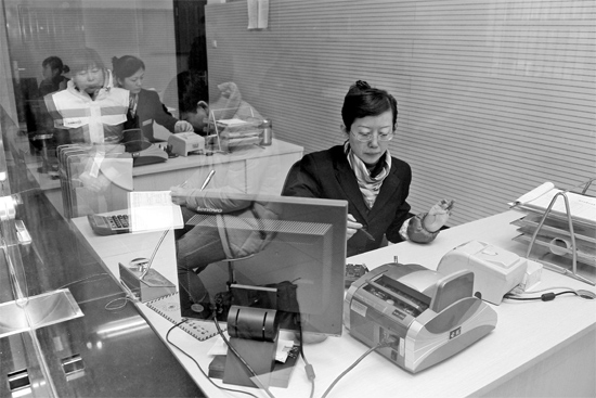 2月16日，鄭州市自來水總公司鄭東新區(qū)一營業(yè)廳，柜臺內(nèi)工作人員正在為市民辦理業(yè)務(wù)