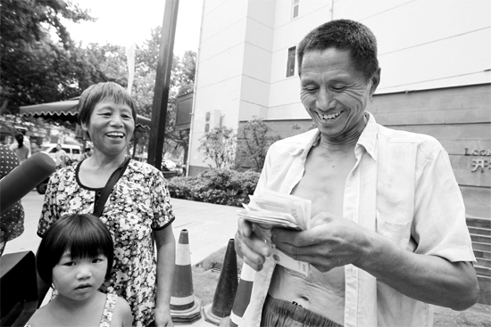 昨日，鄭州市明達(dá)路與豐慶路交叉口西300米路南，來自中牟的瓜農(nóng)拿到西瓜款，笑開顏東方今報記者袁曉強