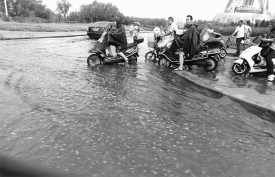 8月7日，鄭州一場(chǎng)暴雨，鄭州多處干道被淹，市民行路如過河