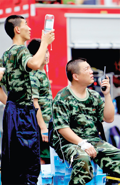 火場外，被消防戰(zhàn)士稱為“李大隊”的救援人員掛著吊瓶現(xiàn)場指揮