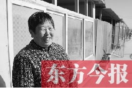 在京水村的臨時過渡區(qū)內，一位大媽在儲存大白菜