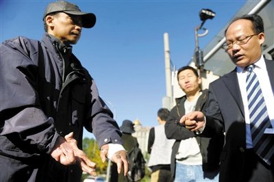 常林鋒在法院外展示雙手，他稱(chēng)被燙傷的手因刑訊逼供且未得到及時(shí)救治