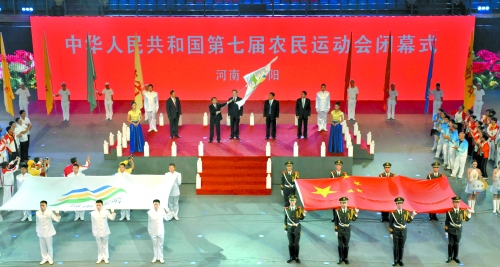 南陽市市長穆為民將農(nóng)運(yùn)會會旗遞交到下一屆東道主吉林省松原市市長李相國手里。