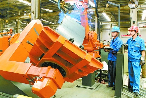 圖為龍工集團中原公司的職工正在操作機器人焊接裝載機。