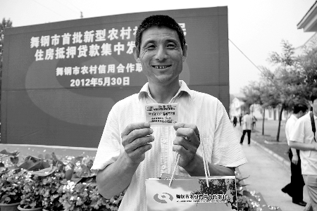 領(lǐng)到貸款，農(nóng)民開心地笑了。