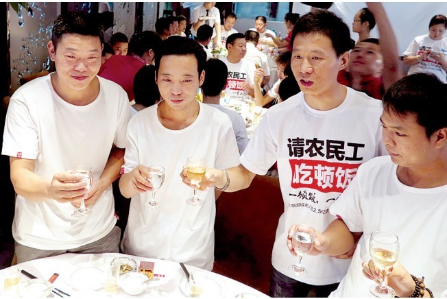 活動發(fā)起人張楠（右二）給農(nóng)民工敬酒。