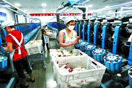 6月6日，舞鋼市鑫海紡織有限公司員工正在新建成的紡紗車間生產(chǎn)。