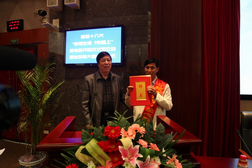 河南平頂山魯山縣電視臺的記者張朝岑，接過了河南電視臺9頻道總監(jiān)張克宣遞上的聘書。