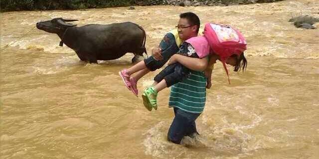 云南一小學(xué)老師常背學(xué)生過(guò)河上學(xué)