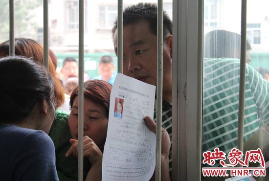 不少家長擠在報名窗口前咨詢報名事宜。