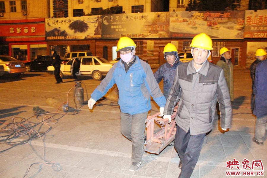 23點56分，第一塊兒廣告牌已經(jīng)分割完畢，地面上的20多名工人將拆除下來的鋼件撞車運走。