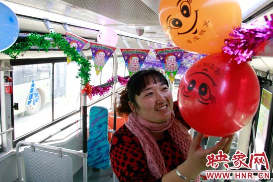 鄭州快速公交B3區(qū)間線車長李鵬云在車廂里懸掛氣球，布置圣誕車廂，營造歡樂圣誕氛圍