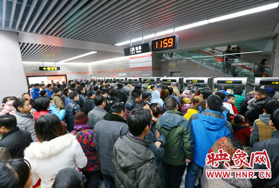 地鐵開通首日，上午十一點五十九分，紫荊山地鐵站售票機前擠滿了買票的市民。