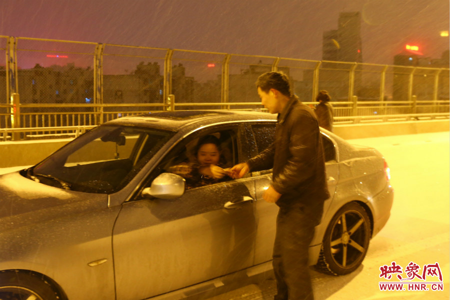 “推車人”幫助一輛車上坡后，收取“勞務(wù)費(fèi)”。