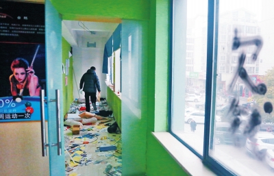 　健身會所地上一片狼藉，玻璃上噴著黑色“欠錢”二字。