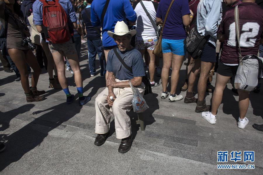 一名男子坐在參加不穿褲子搭地鐵的人群邊小憩。