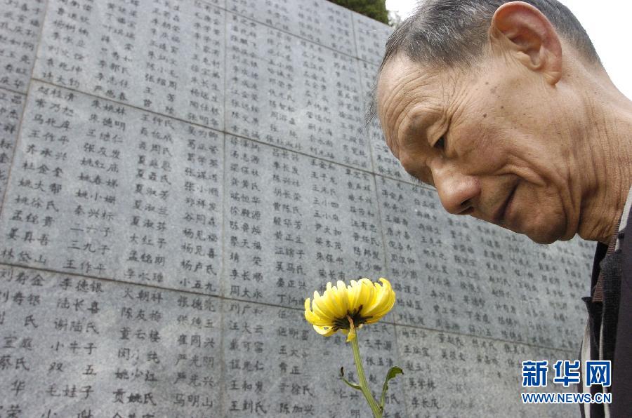 2006年4月5日，74歲的南京大屠殺幸存者佘子清手捧鮮花，祭奠被日軍殺害的母親。