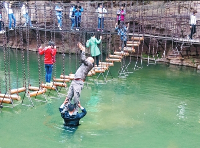 中年男游客正踩著景區(qū)安全員郭小明的肩膀過河。網(wǎng)友“@我的小名叫張孩”供圖