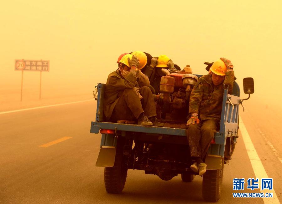 4月23日，一輛拉載公路施工人員的三輪車在沙塵暴中行駛在酒泉市瓜州縣城郊的公路上。