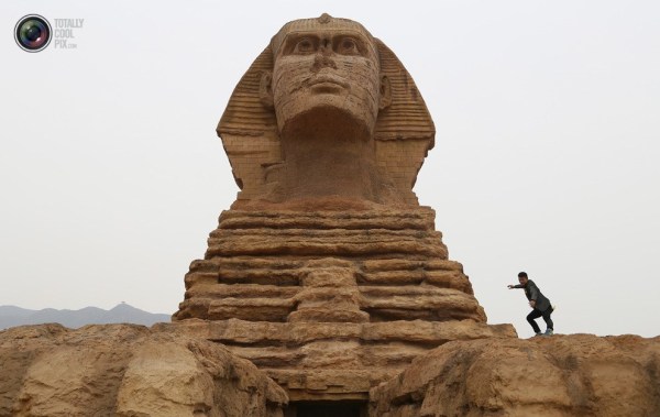 石家莊郊外，一名男子與山寨版獅身人面像合影留念。