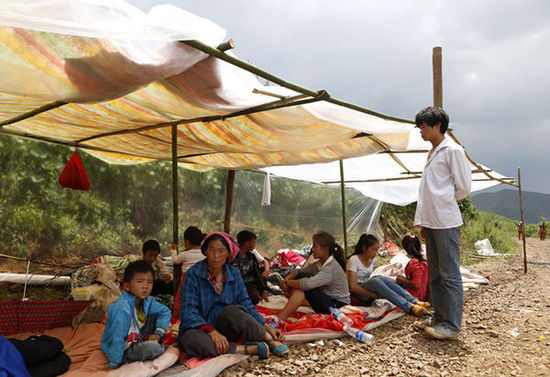 暴雨馬上來臨，村民們在簡易帳篷下躲雨。澎湃新聞 程藝輝 圖