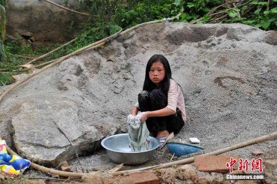 8月9日，云南巧家紅石巖村，10歲的劉鑫蕊在洗自己的衣服